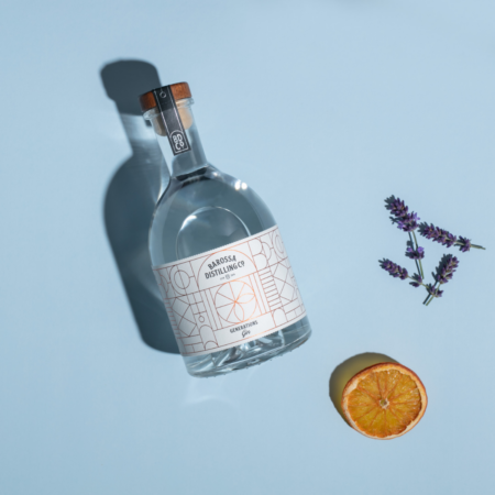 Generations Gin laying flat with lavender and a dehydrated orange